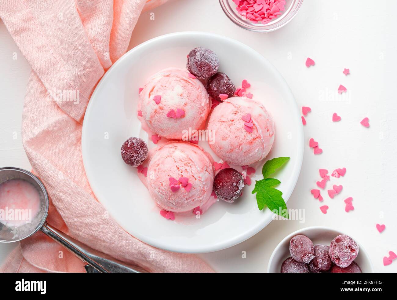 Obst- und Speiseeis mit gefrorenen Kirschen auf hellem Hintergrund. Draufsicht, horizontal. Stockfoto