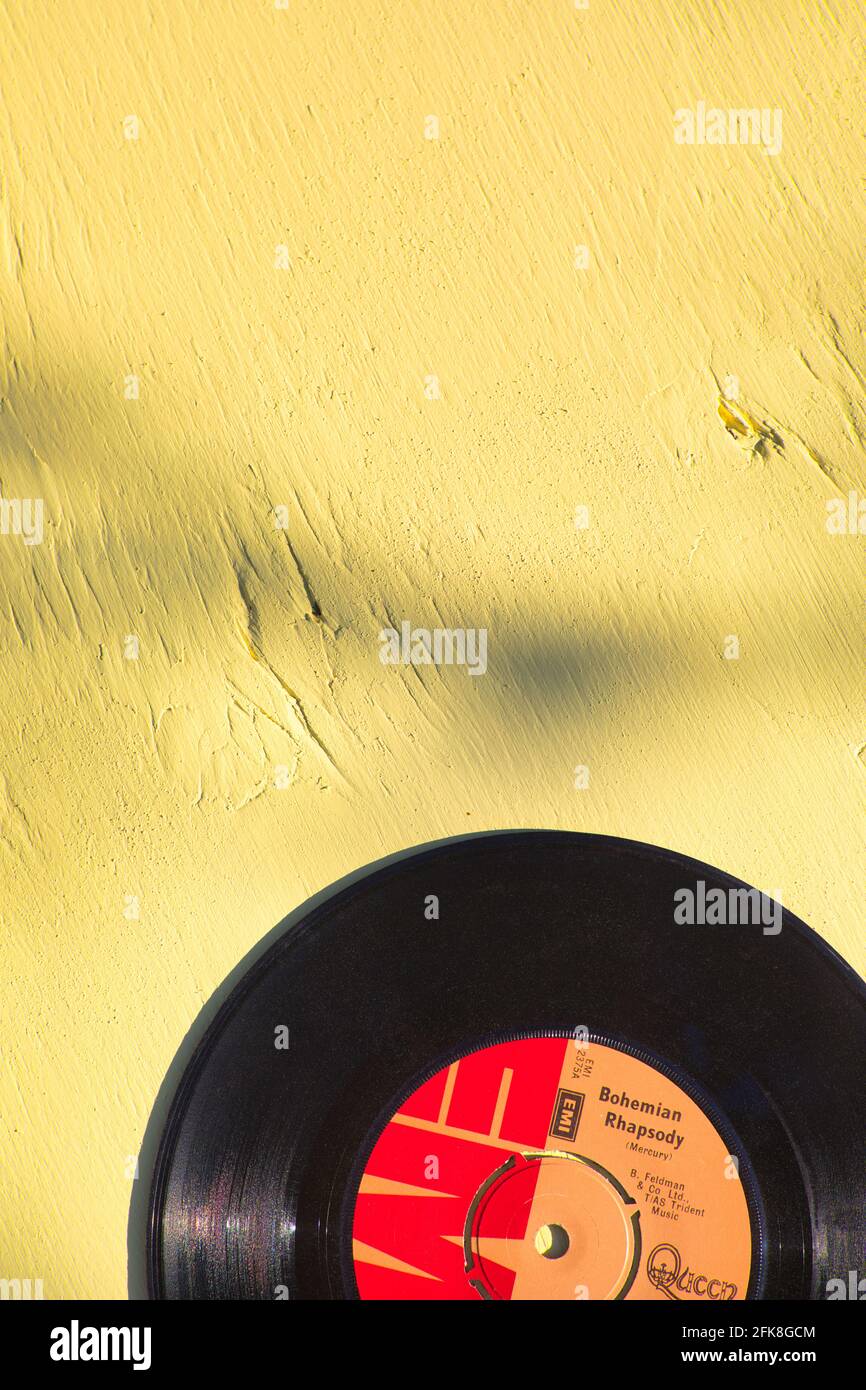 Bohemian Rhapsody von Queen 7 Zoll 45 U/min Single auf gelbem Holzhintergrund. Konzept von Nostalgie, Vergangenheit, Erinnerungen Stockfoto