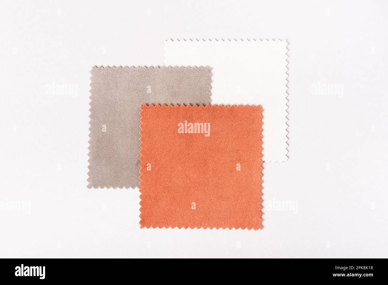 Quadratische Samtstoffmuster in überlappender Anordnung in Orange, Grün, Blau, Grau und Weiß auf weißem Hintergrund Stockfoto Quadratische Samtstoffmuster in überlappender Anordnung in Orange, Grün, Blau, Grau und Weiß auf weißem Hintergrund Stockfoto