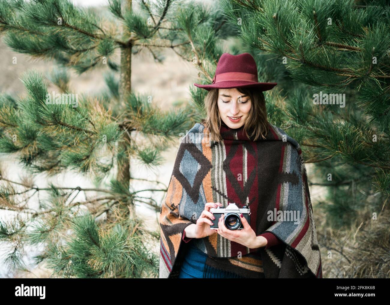 Junge Frau in einem Wald mit einem Vintage Kamera. Kinfolk/im freien Stil. Stockfoto