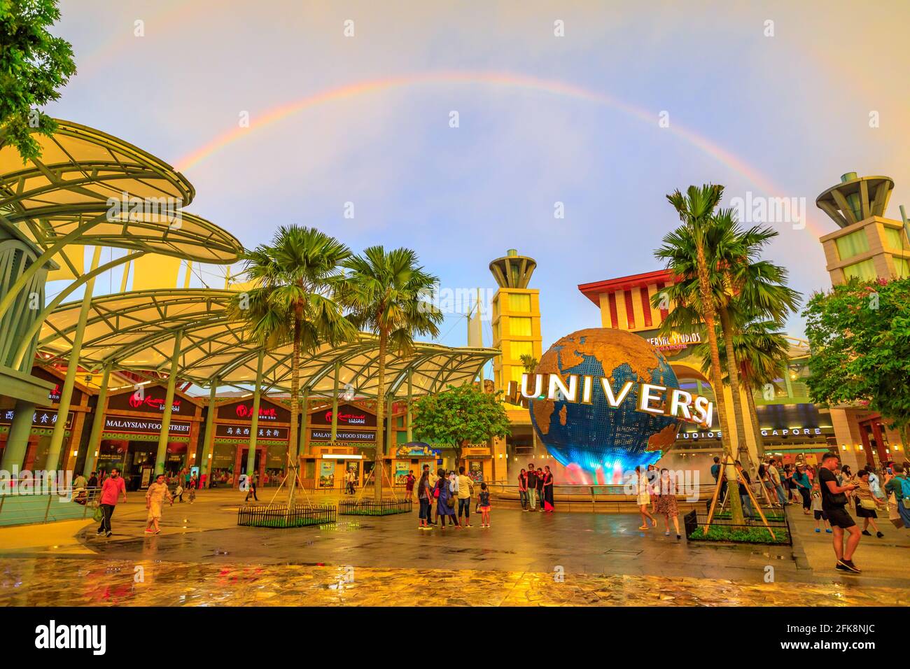 Singapur - 2. Mai 2018: regenbogen nach einem Gewitter in Sentosa bei Sonnenuntergang. Universal Studios Moving Globe im Bull Ring Square auf dem Hintergrund Stockfoto