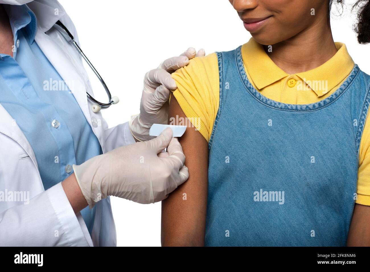 Beschnittene Ansicht des Arztes, der Klebstoffputz auf den Arm des afroamerikanisches Kind auf Weiß isoliert Stockfoto