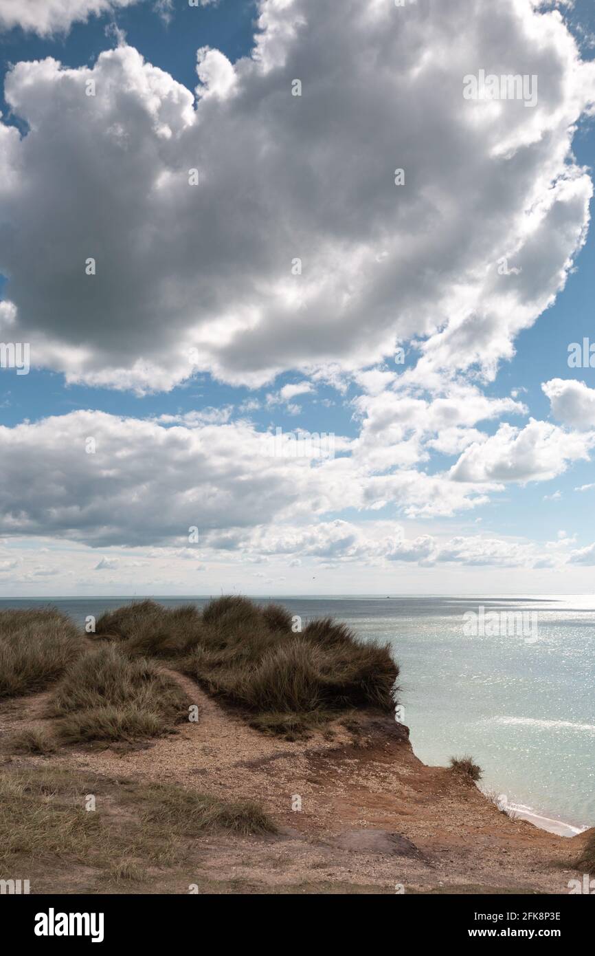 Ein Blick über den Ozean an der Südküste Englands mit blauem Himmel und dramatischen Wolken darüber. Stockfoto