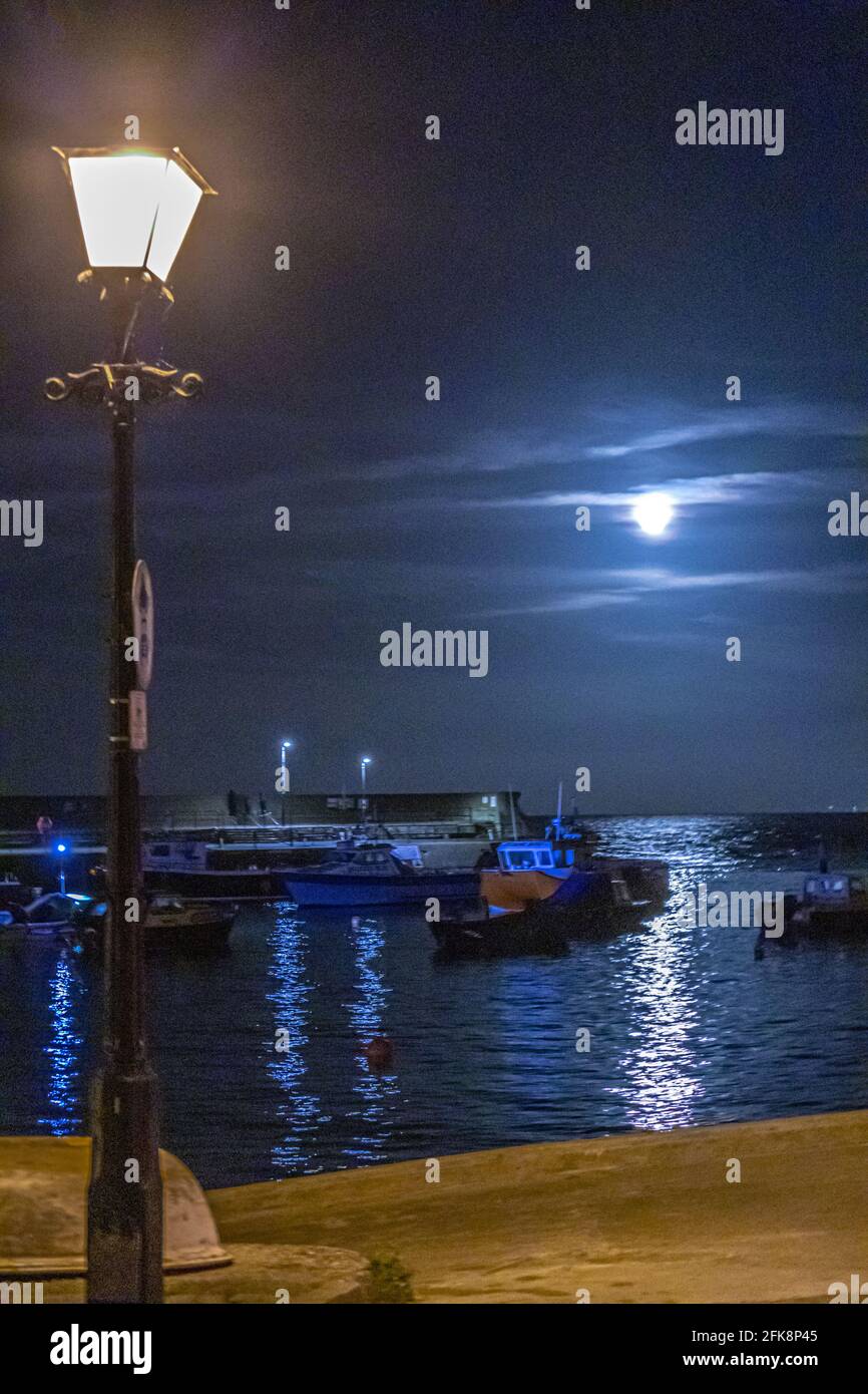 Ein Erntemond, der bei einer Flut im Minehead Harbour, Somerset, Großbritannien, aufsteigt Stockfoto