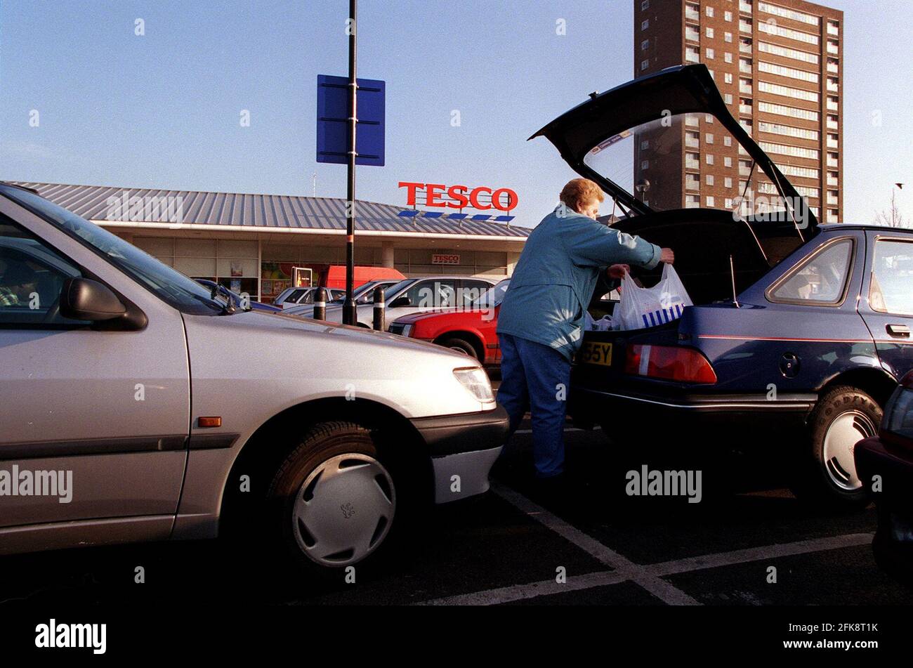 Tesco Supermarkt Januar 2000Hackney Tesco Supermarkt Frau Laden Einkaufen in Kofferraum auf dem Parkplatz Stockfoto