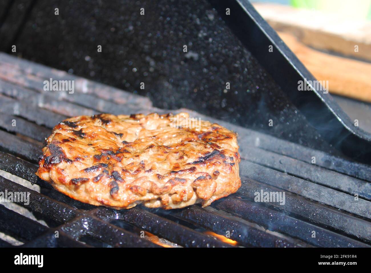 Nahaufnahme eines Hamburgerpastys beim Kochen auf einem Barbecue-Grill. Stockfoto