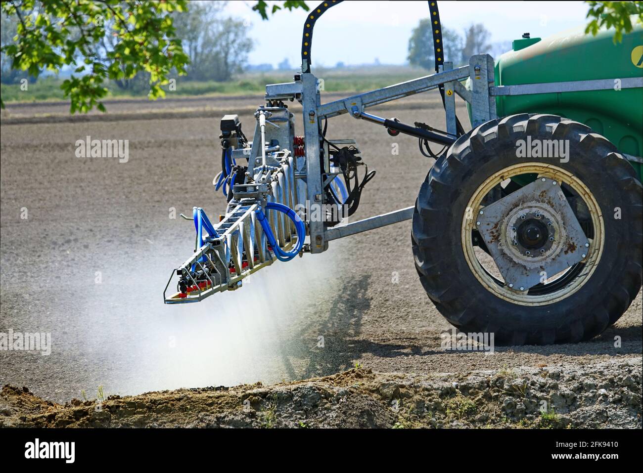 Traktor sprüht Weizenfeld mit Sprüher, Herbiziden und Pestiziden. Frühfrühling von Pestiziden sprühen. Chemische Behandlung in der Landwirtschaft. Stockfoto