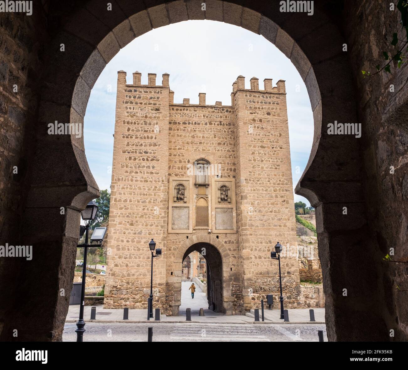 Blick auf die mittelalterliche Brücke von Alcantara über den Fluss Tejo in Toledo durch einen der Bögen in der Wand, Spanien. Stockfoto