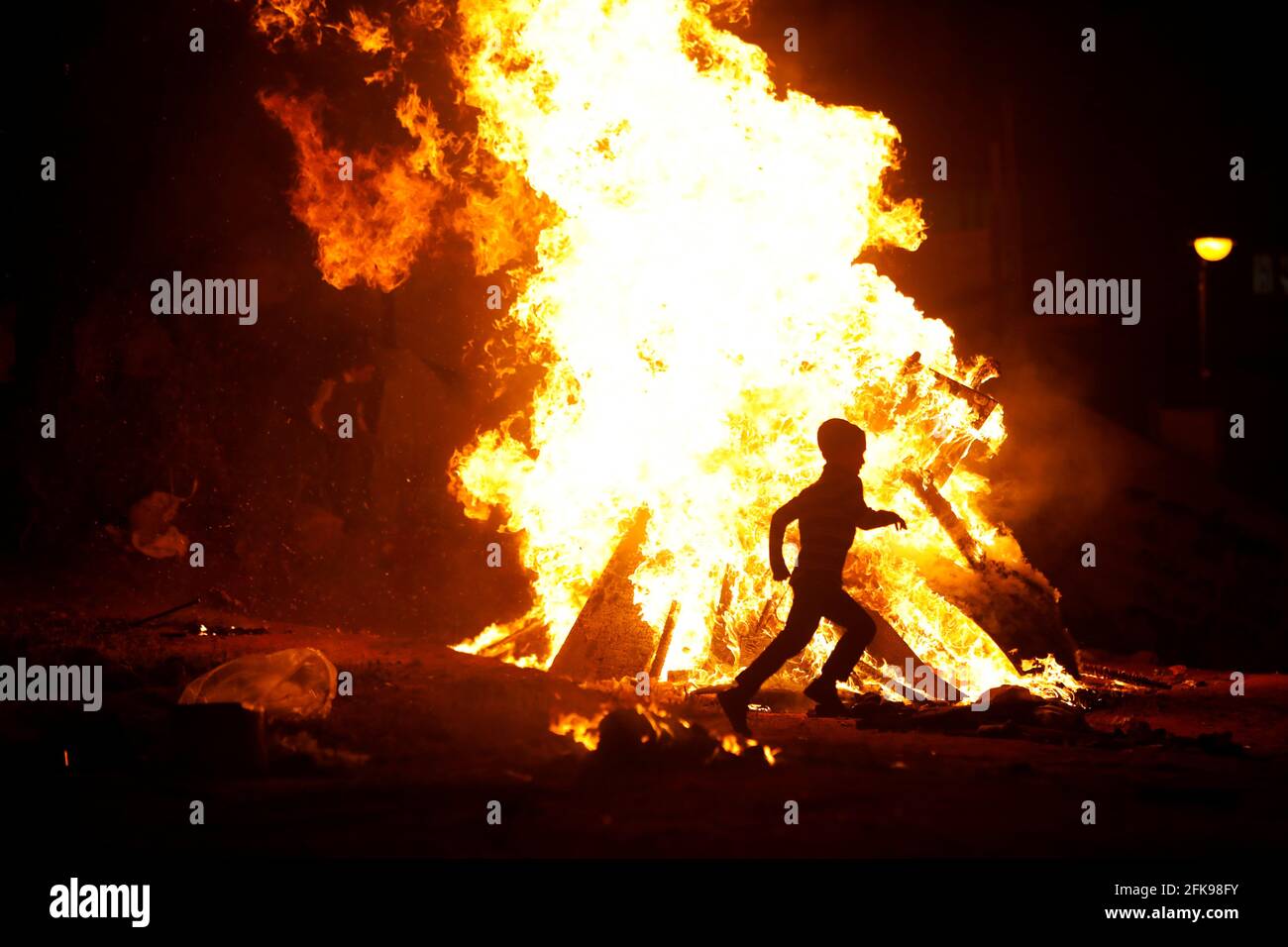 Ein Junge rennt um ein Lagerfeuer, als Ultra-orthodoxe Juden den jüdischen Feiertag von lag Ba'Omer in Bnei Brak, nahe Tel Aviv, Israel, am 29. April 2021, markieren. REUTERS/NIR Elias Stockfoto