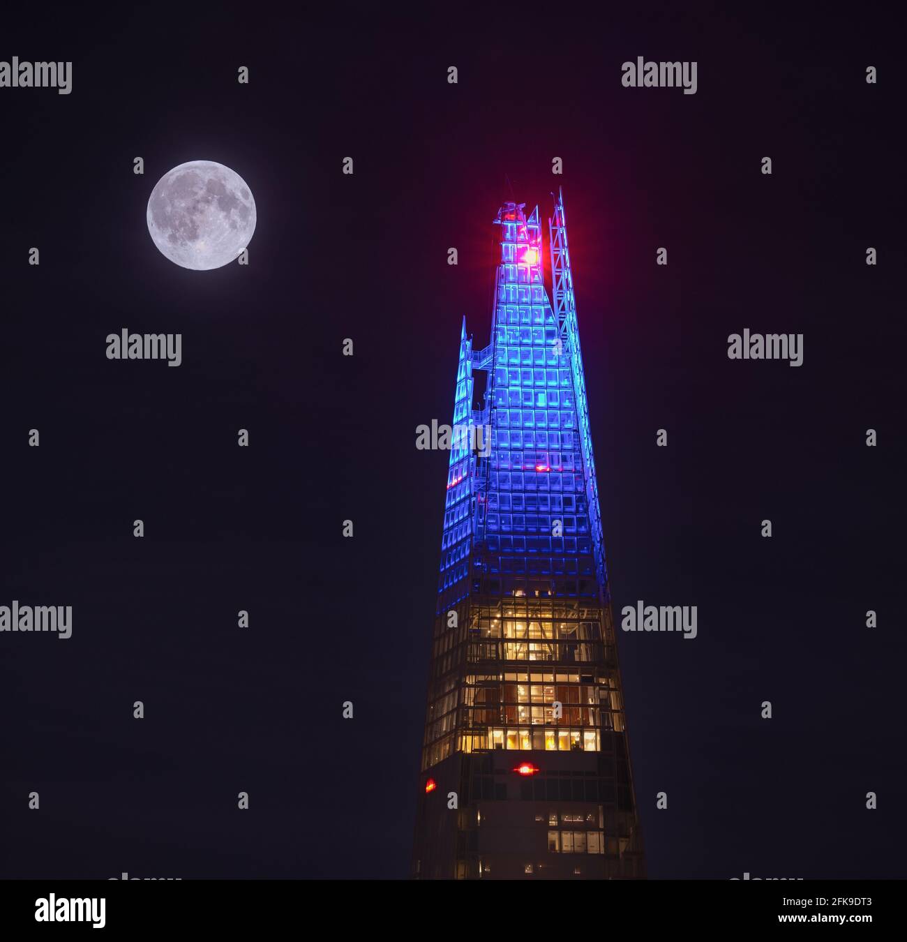 Supermoon erhebt sich hinter dem Shard in London Stockfoto
