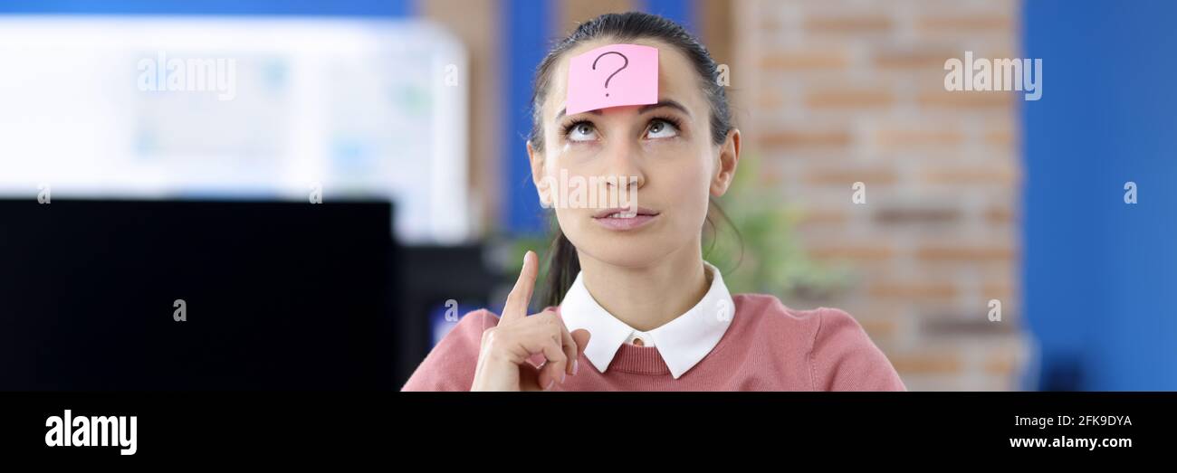 Pinker Aufkleber mit Fragezeichen, das an der Stirn der Frau klebt Stockfoto