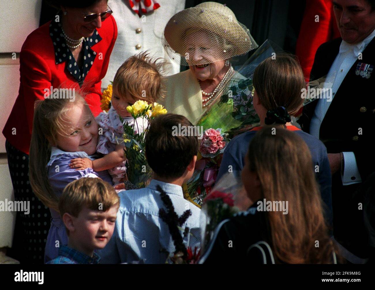 Kinder, die der Königin Mutter am 1998. August ihren 98. Geburtstag Blumen schenken. Stockfoto