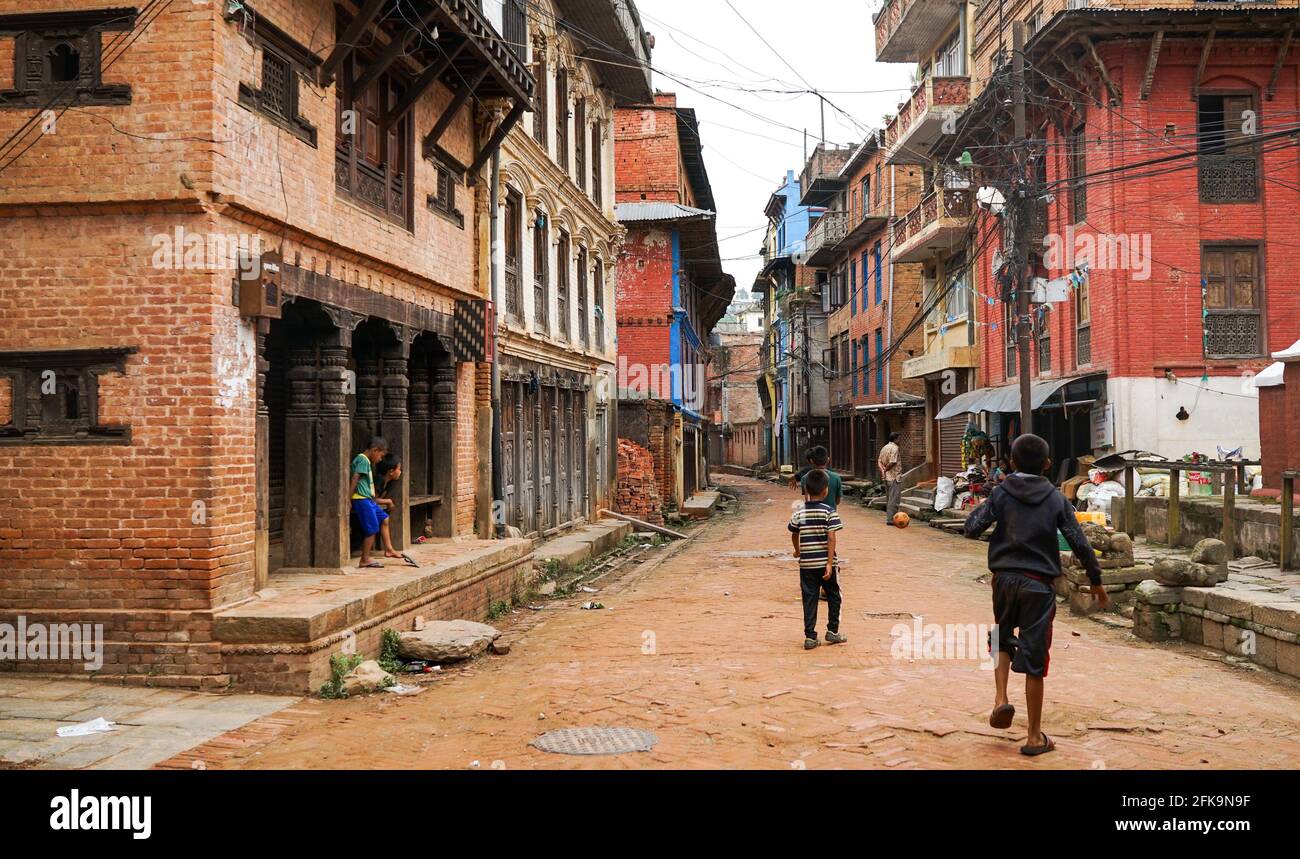 Panauti, Nepal - Oktober 2019: Leere Straßen in Panauti, Nepal, alte traditionelle Architektur, Kinder spielen Fußball Stockfoto