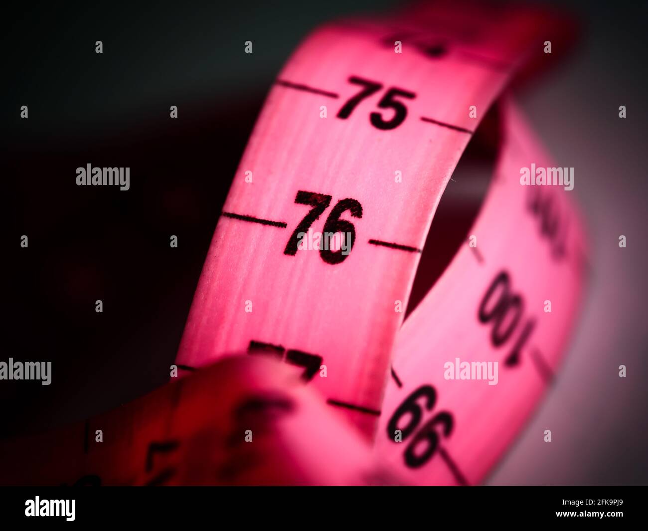 Nahaufnahme Maßband auf weißem Tischhintergrund. Weißes Messband für geringe Schärfentiefe. Makro. Stockfoto