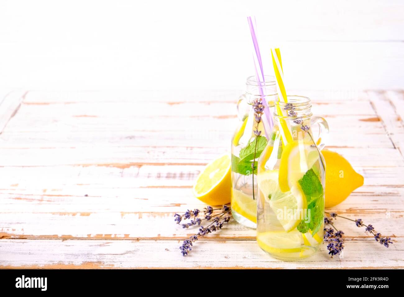 Eiskalte Lavendellimonade, Zitrone, Stroh. Zwei klassische Mojito-Drinks, alkoholfreier Cocktail mit Eis in zwei Vintage-Hipster-Flaschen, auf grunged Stockfoto