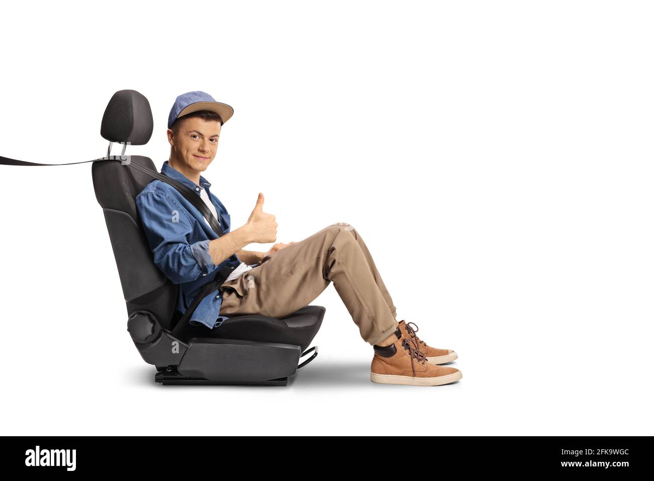 Männlicher Teenager auf einem Autositz mit einem Sicherheitsgurt Daumen hoch isoliert auf weißem Hintergrund Stockfoto