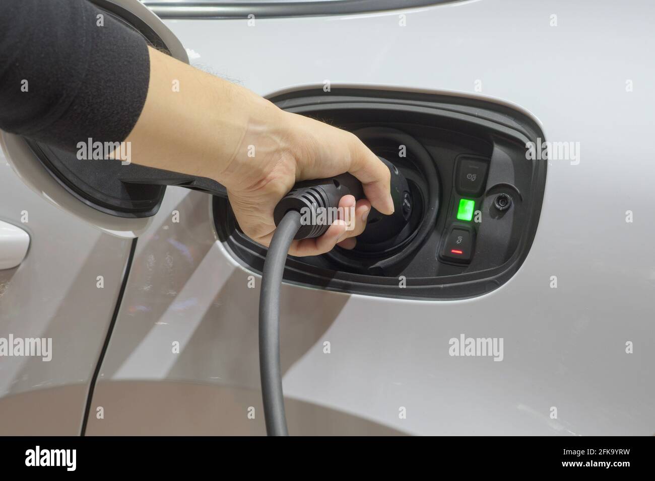 Nahaufnahme asiatischer Männer Hände, die ein neues Fahrzeug anheizen Elektrifizierung über wiederaufladbare Strommaschine Stockfoto