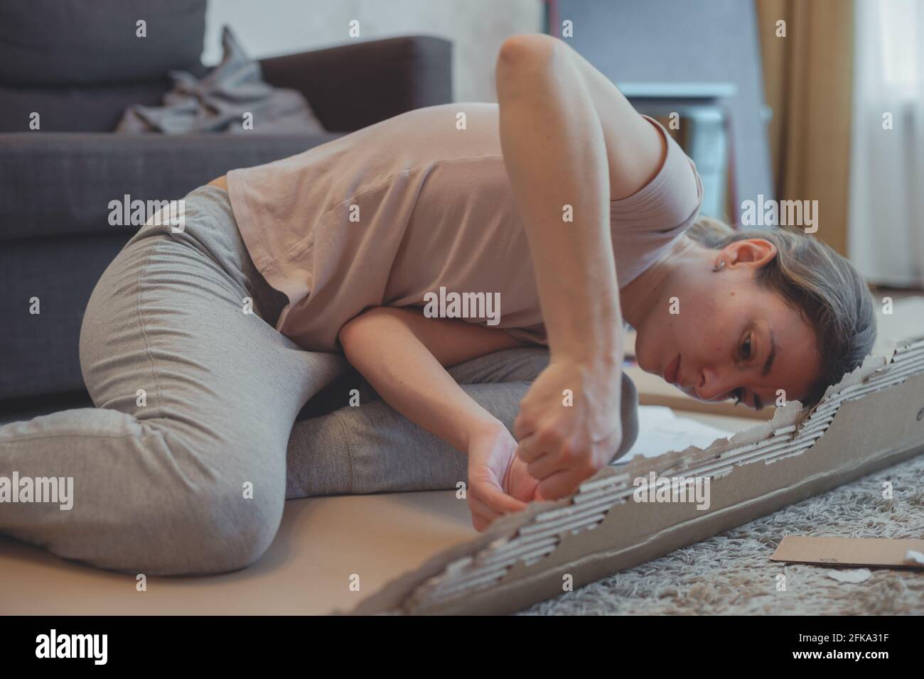 Attraktive Mädchen Hausfrau mit einem Schraubendreher montiert Möbel auf ihre eigene. Stockfoto