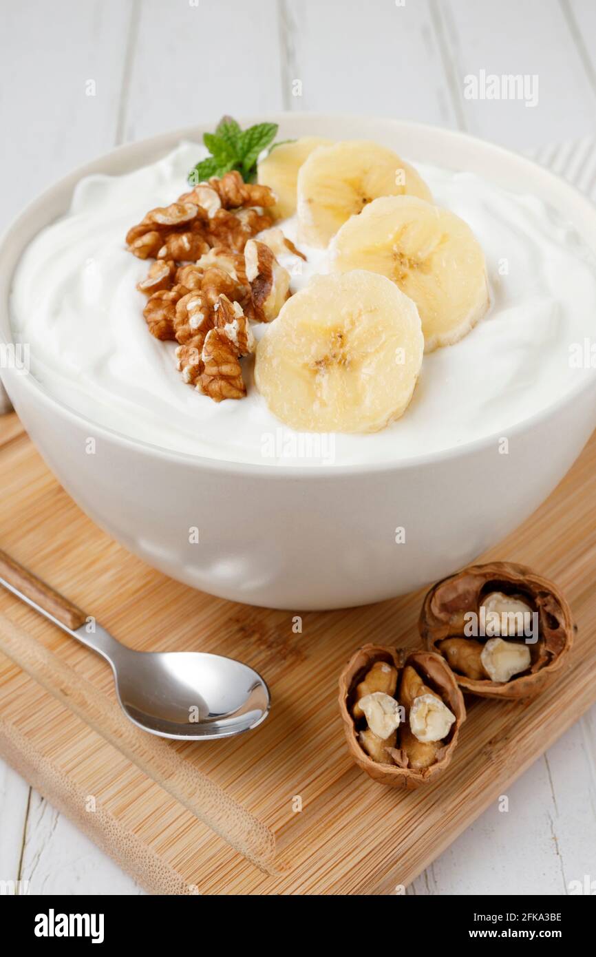 Joghurt-Frühstück mit Banane und Walnüssen Stockfoto