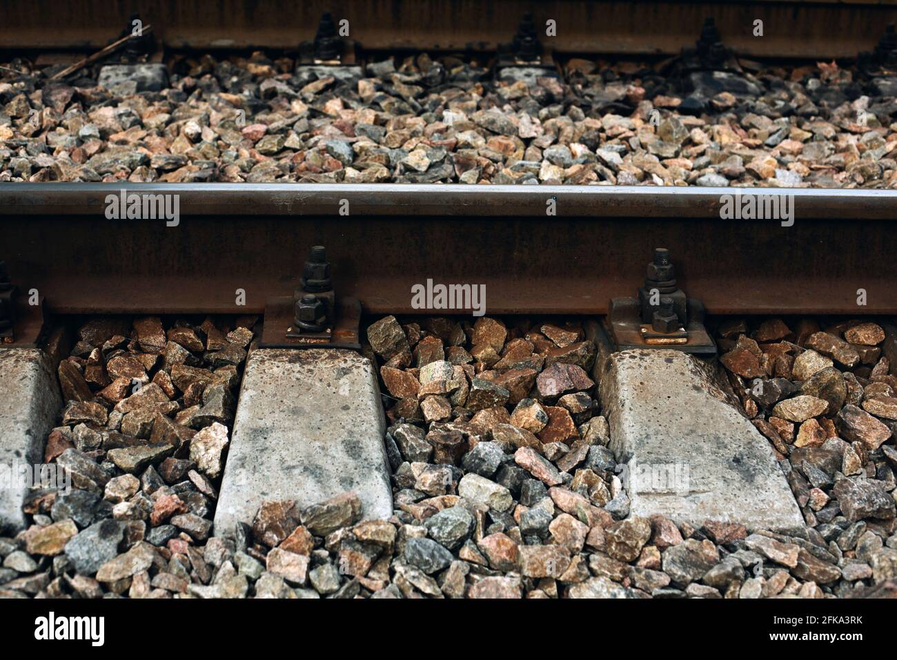 Nahaufnahme der Metallbahn mit Steinen und Beton, alte Technik Stockfoto