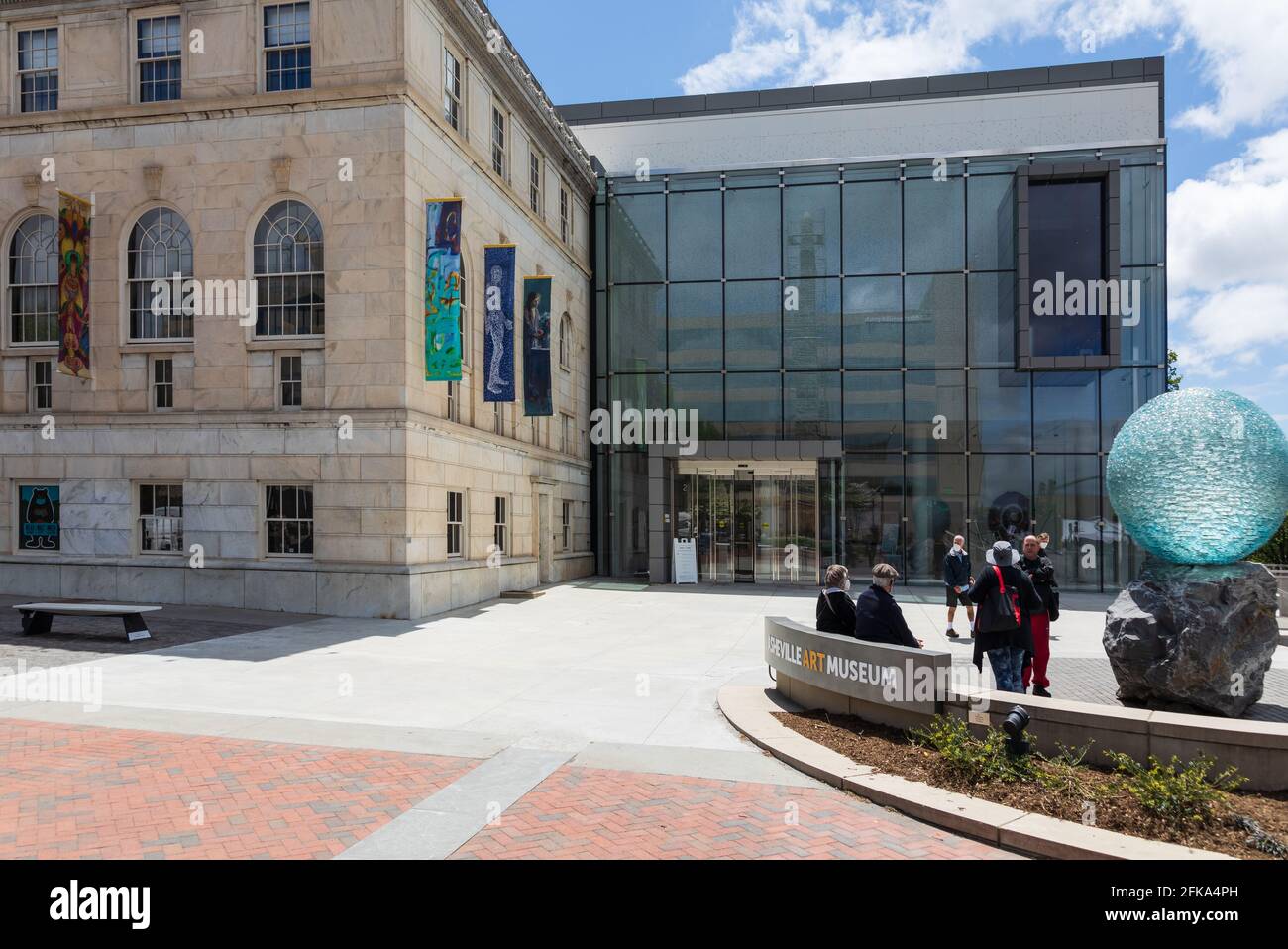 ASHEVILLE, NC, USA-25 APRIL 2021: 6 Menschen vor dem Asheville Ar Museum, neben dem großen blauen Kugelkunstwerk. Stockfoto