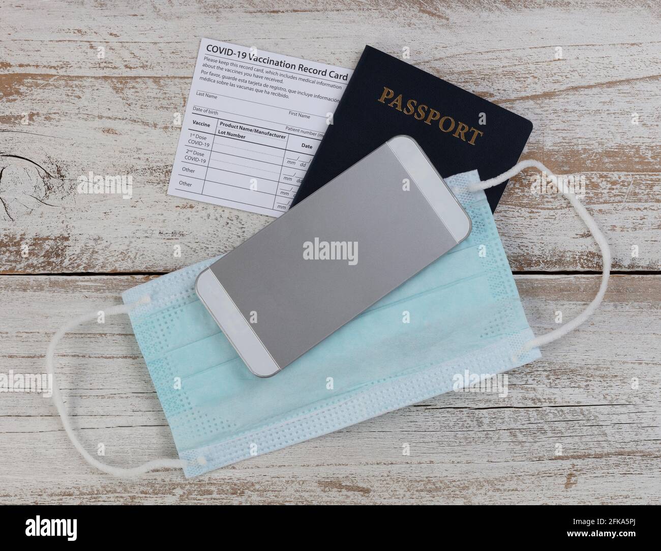 Impfpass Covid 19, US-Pass, Gesichtsmask und Smartphone in Nahaufnahme Stockfoto