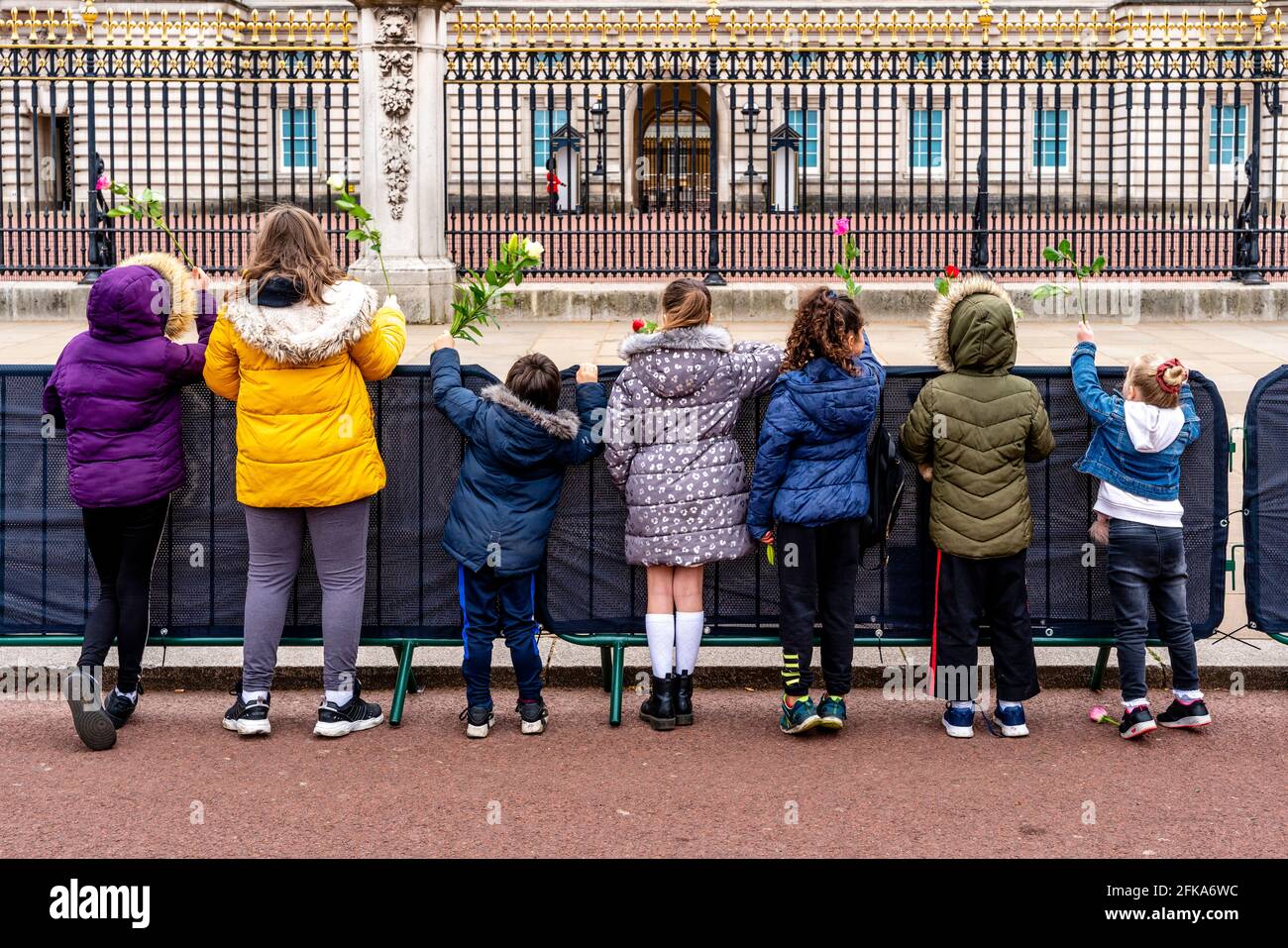 Eine Gruppe britischer Kinder warten darauf, Blumen vor den Toren des Buckingham Palace nach dem Tod von Prinz Philip, London, Großbritannien, zu legen. Stockfoto