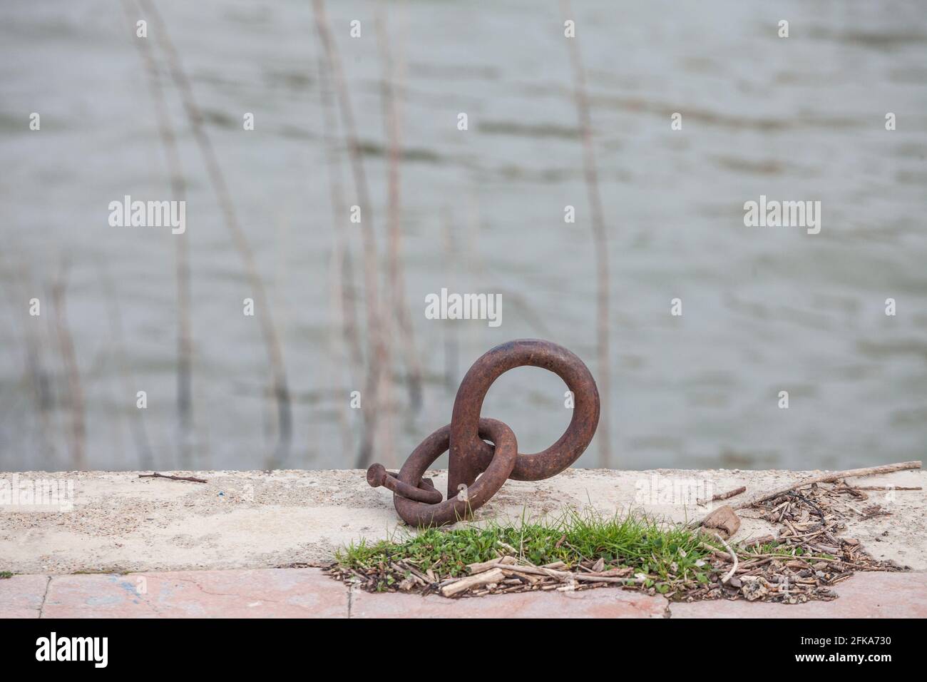 Bild eines Anlegerings, der zum Ankern von Booten an einem Kai auf einem Hafen am Fluss neben dem Meer verwendet wurde. Stockfoto