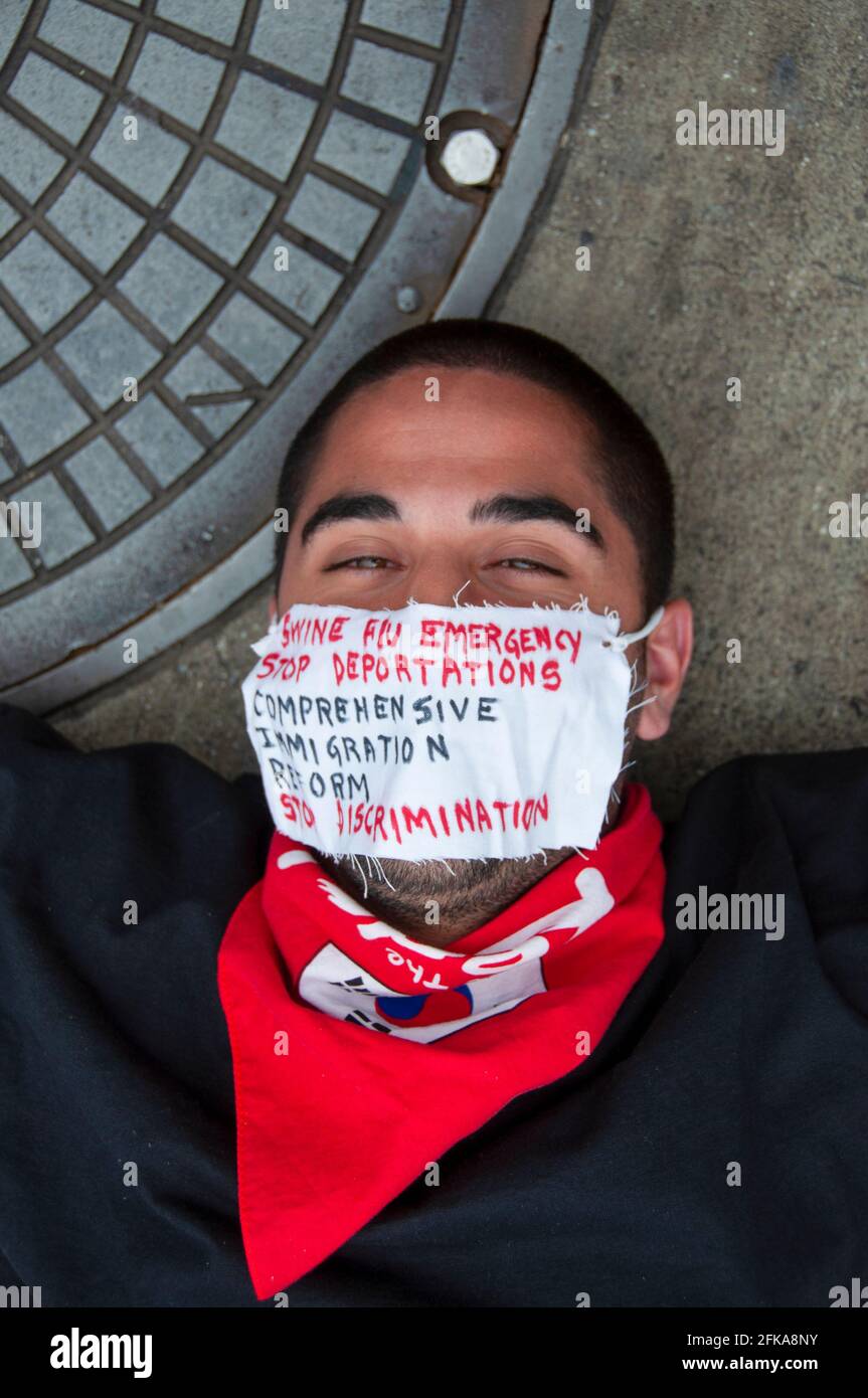 Ein Mann, der eine Maske trägt, mit Botschaften über die Schweinegrippe und die Proteste der Einwanderungspolitik während der Mayday-Proteste 2009 in Downtown Los Angeles, CA. Stockfoto