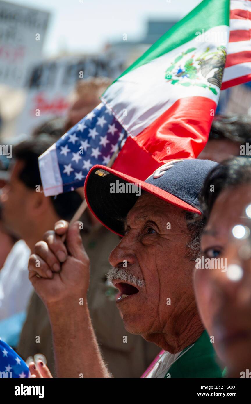 2009 winkt ein Mann bei einer Mayday-Kundgebung in Downtown Los Angeles zusammen mit einer amerikanischen und einer mexikanischen Flagge. Stockfoto