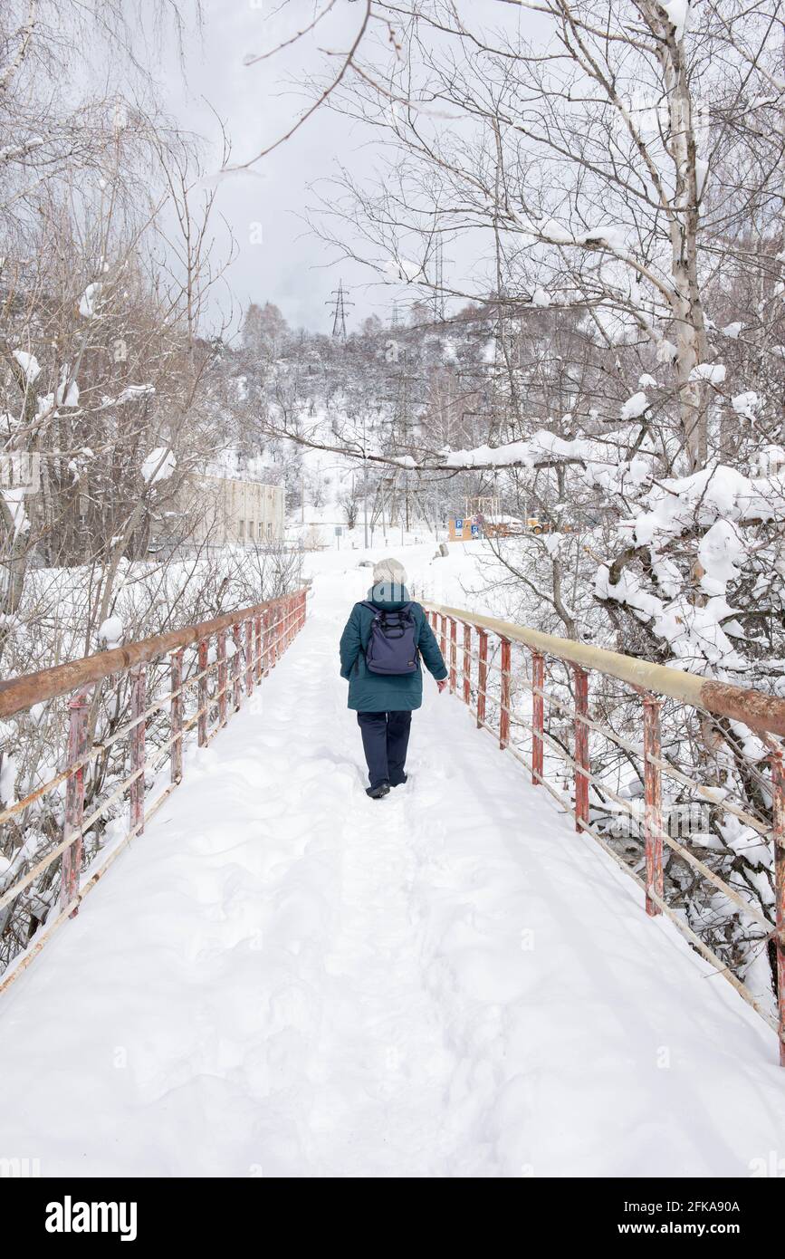 Eine Brücke im Schnee über einen Bergfluss Stockfoto