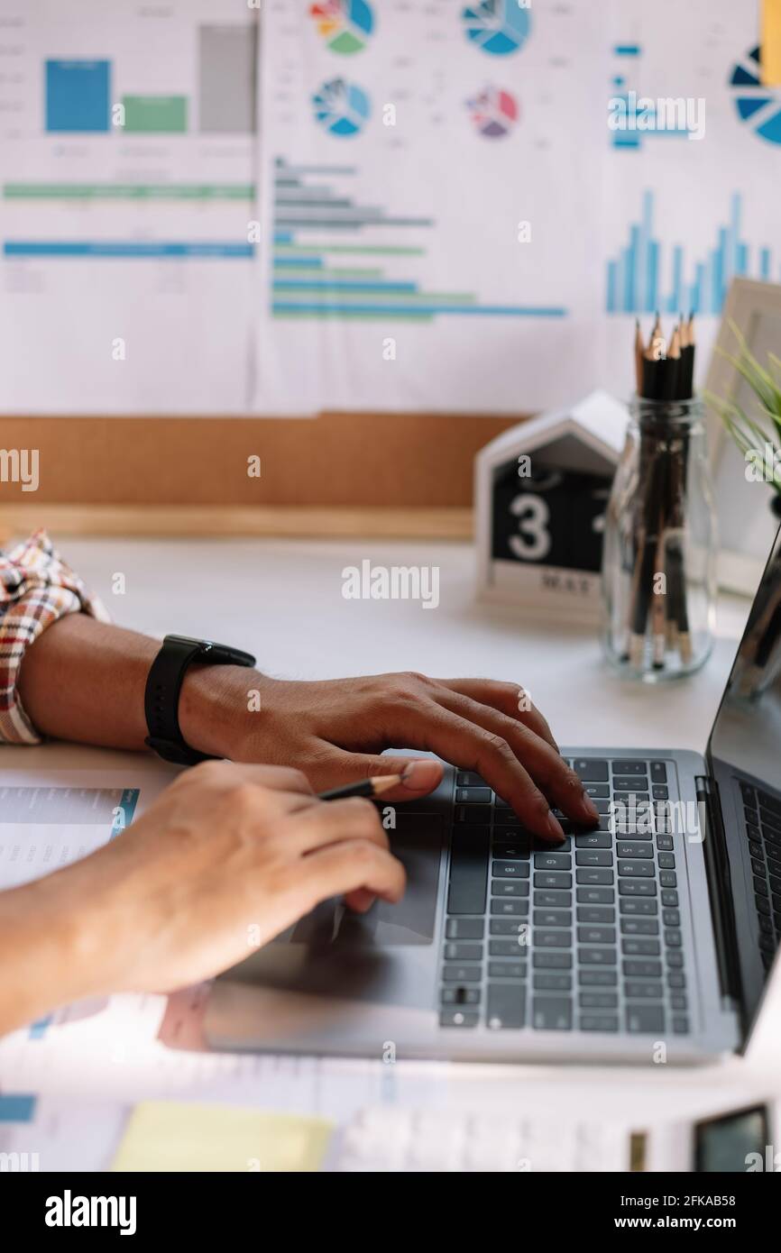 Nahaufnahme der Hand des Mannes mit lapto.p Computer mit Geschäft monatlichen Bericht. Stockfoto