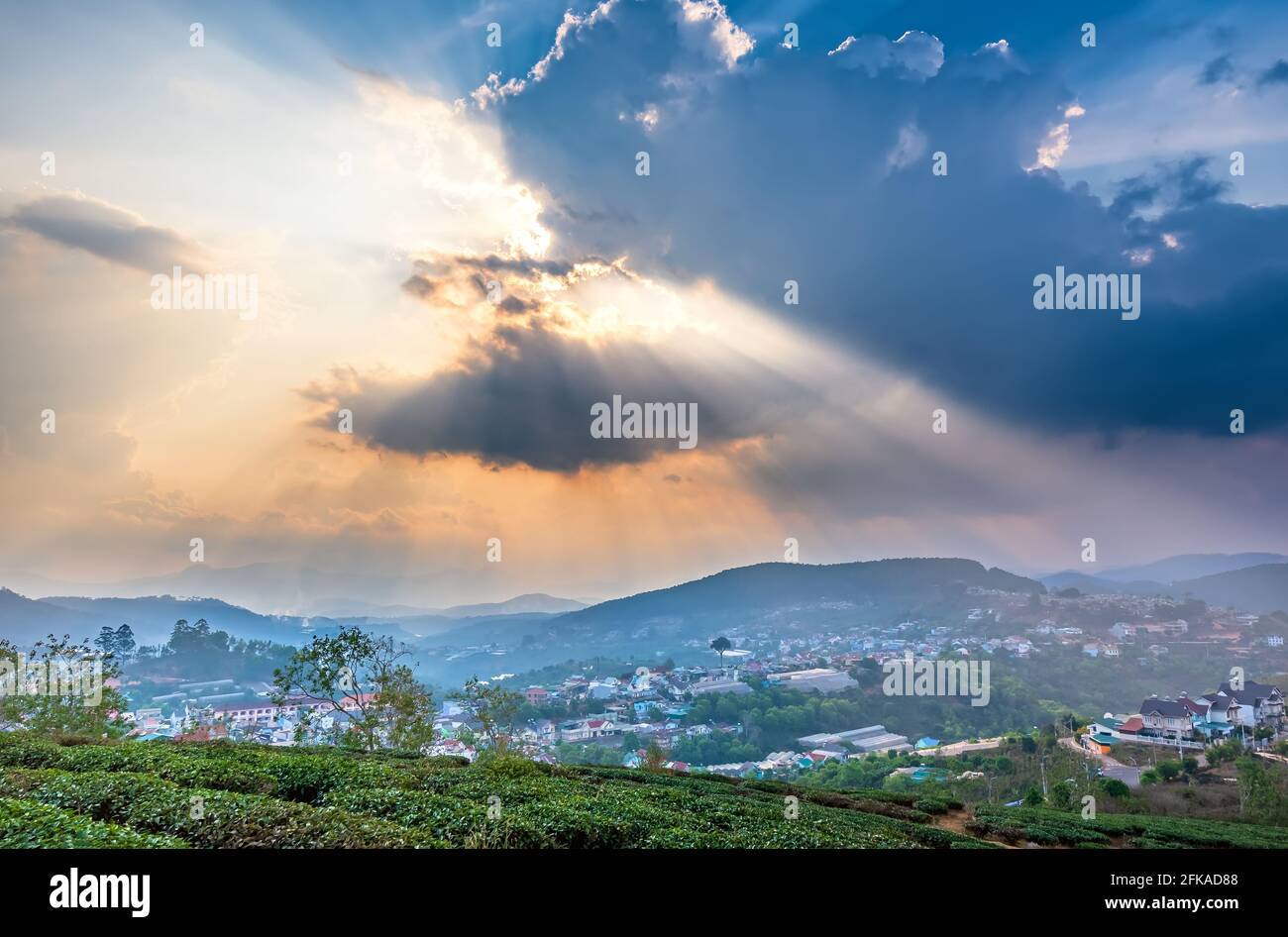 Blick auf den Sonnenuntergang im Hochland mit dramatischem Himmel und Schönes kleines Dorf in der Ferne, um ein friedliches Ende Tag Stockfoto