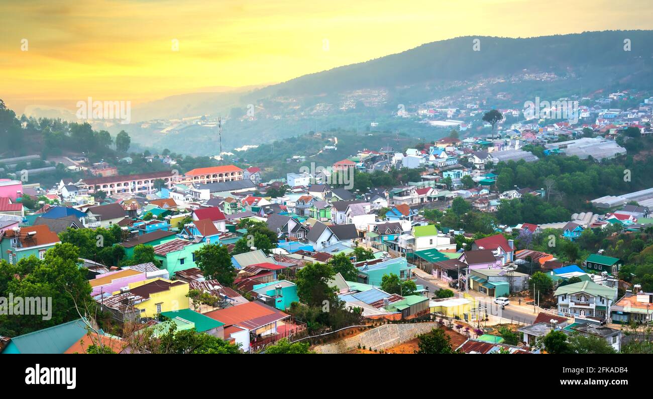 Blick auf den Sonnenuntergang im Hochland mit dramatischem Himmel und Schönes kleines Dorf in der Ferne, um ein friedliches Ende Tag Stockfoto