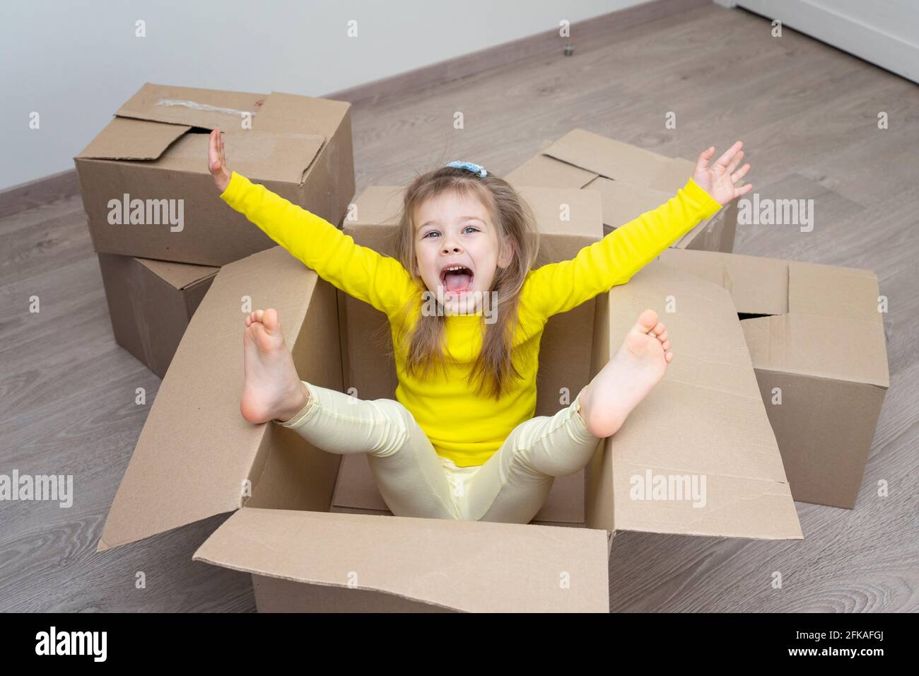 Umzug in eine neue Wohnung. Glückliches Baby in einem Karton Stockfoto