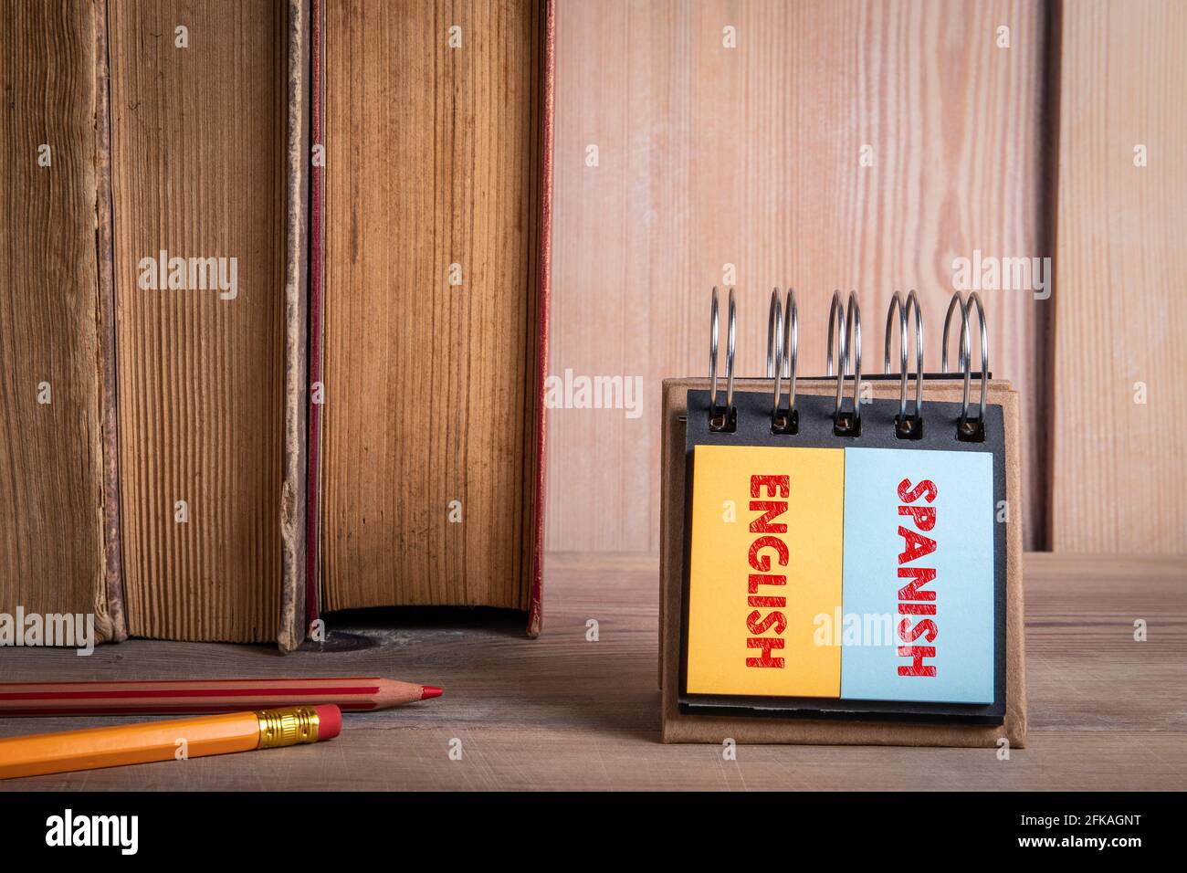 Englisch und Spanisch lernen. Bücher auf einem hölzernen Bücherregal. Stockfoto