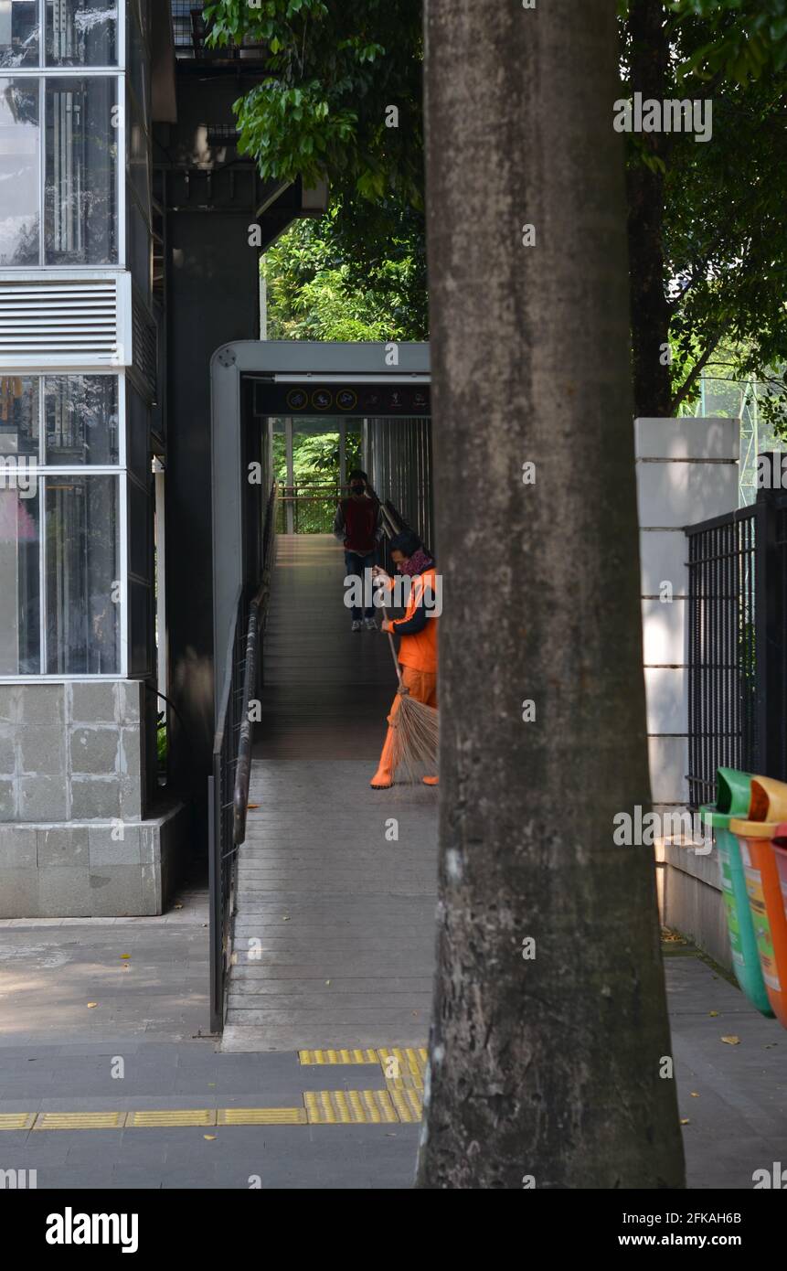 Senayan, Jakarta, Indonesien - 23. April 2021: Ein Straßenreiniger in Orange säugt die Straße. Stockfoto