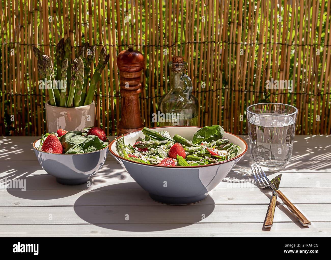 Frische Erdbeeren, grüner Spargel, Feta-Käse, Babyspinat und Rucola-Salat in einer Schüssel serviert Stockfoto