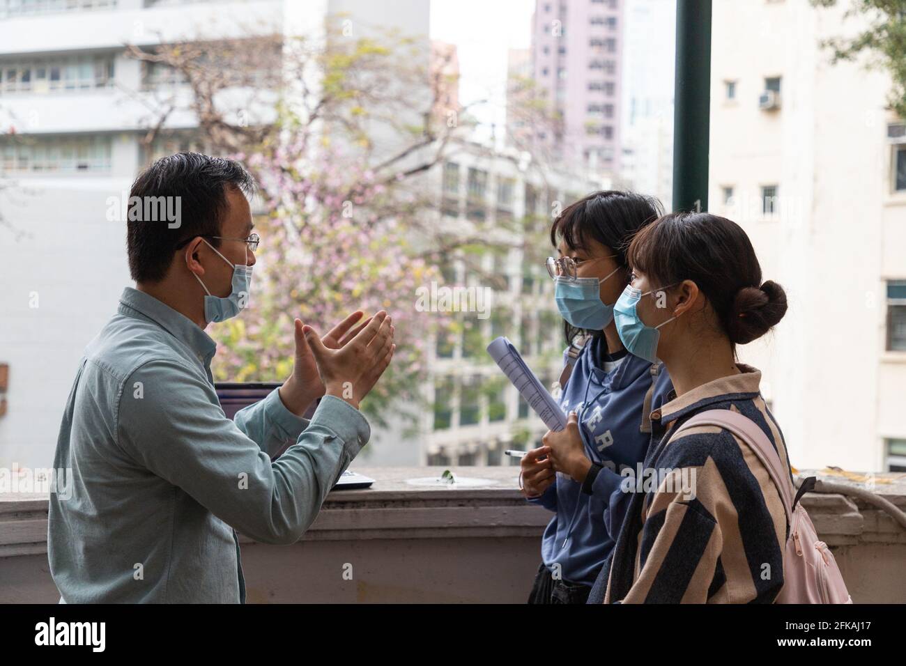 27 2 2021 Universität oder Hochschule mit Gesichtsmaske männlich Die Lehrerin erklärt den Schülerinnen während eines Feldtests außerhalb des Klassenzimmers In der Universität in Hongkong Stockfoto