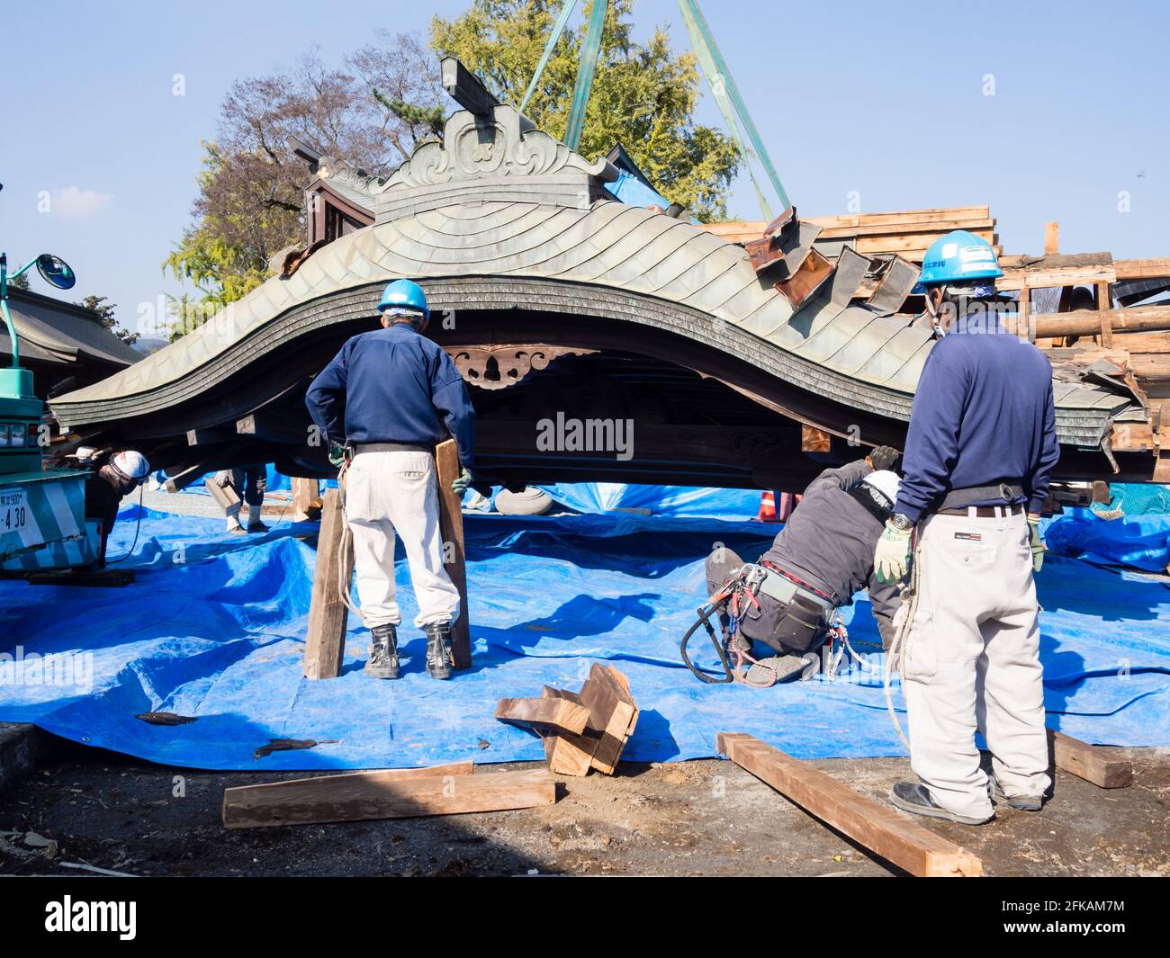 Aso, Japan - 5. November 2016: Das Dach der eingestürzten Halle wurde nach den Erdbeben in Kumamoto 2016 von den Arbeitern im schwer beschädigten Aso-Schrein vorsichtig angehoben Stockfoto