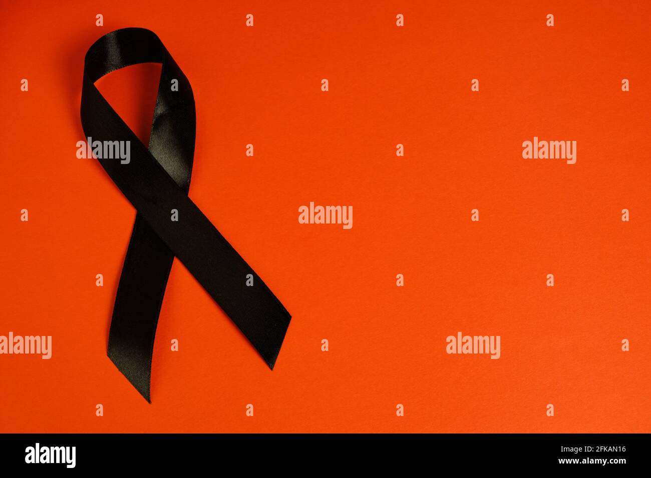 Schwarzes Band auf rotem Hintergrund ist Symbol-Melanom, Symbol der Gedächtnisopfer Stalinismus und Nazismus und Gedächtnisveranstaltungen am Virginia Polytechnic Institute Stockfoto