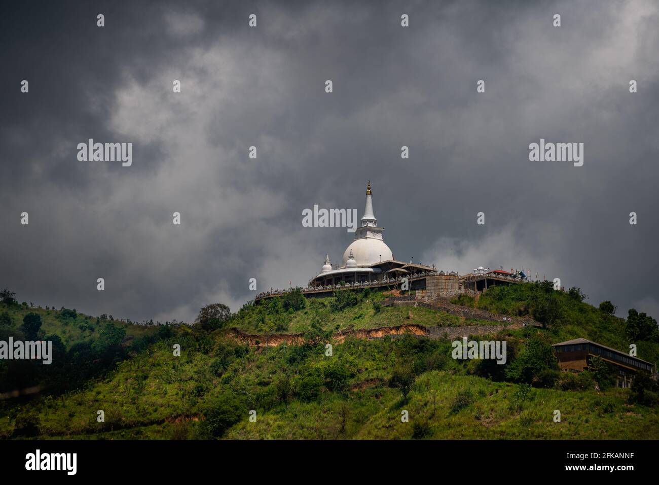 Mahamevnawa Buddhist Monastery Tempel in der Bergspitze niedrigen Winkel landschaftliche Ansicht. Dunkle Regenwolken und kalte Atmosphäre in Bandarawela, Stupa Stockfoto