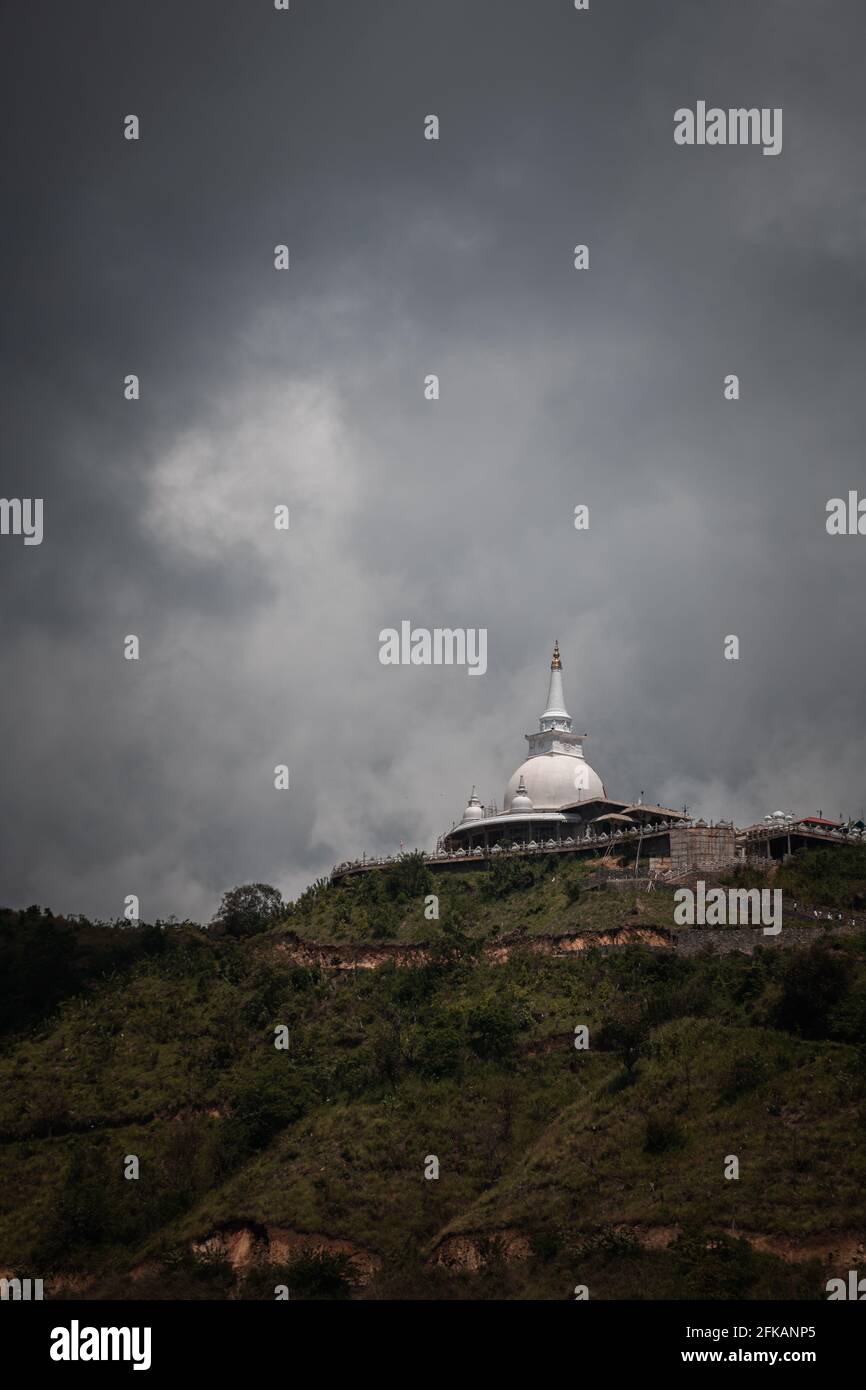 Mahamevnawa Buddhist Monastery Tempel in der Bergspitze niedrigen Winkel landschaftliche Ansicht. Dunkle Regenwolken und kalte Atmosphäre in Bandarawela, Stupa Stockfoto
