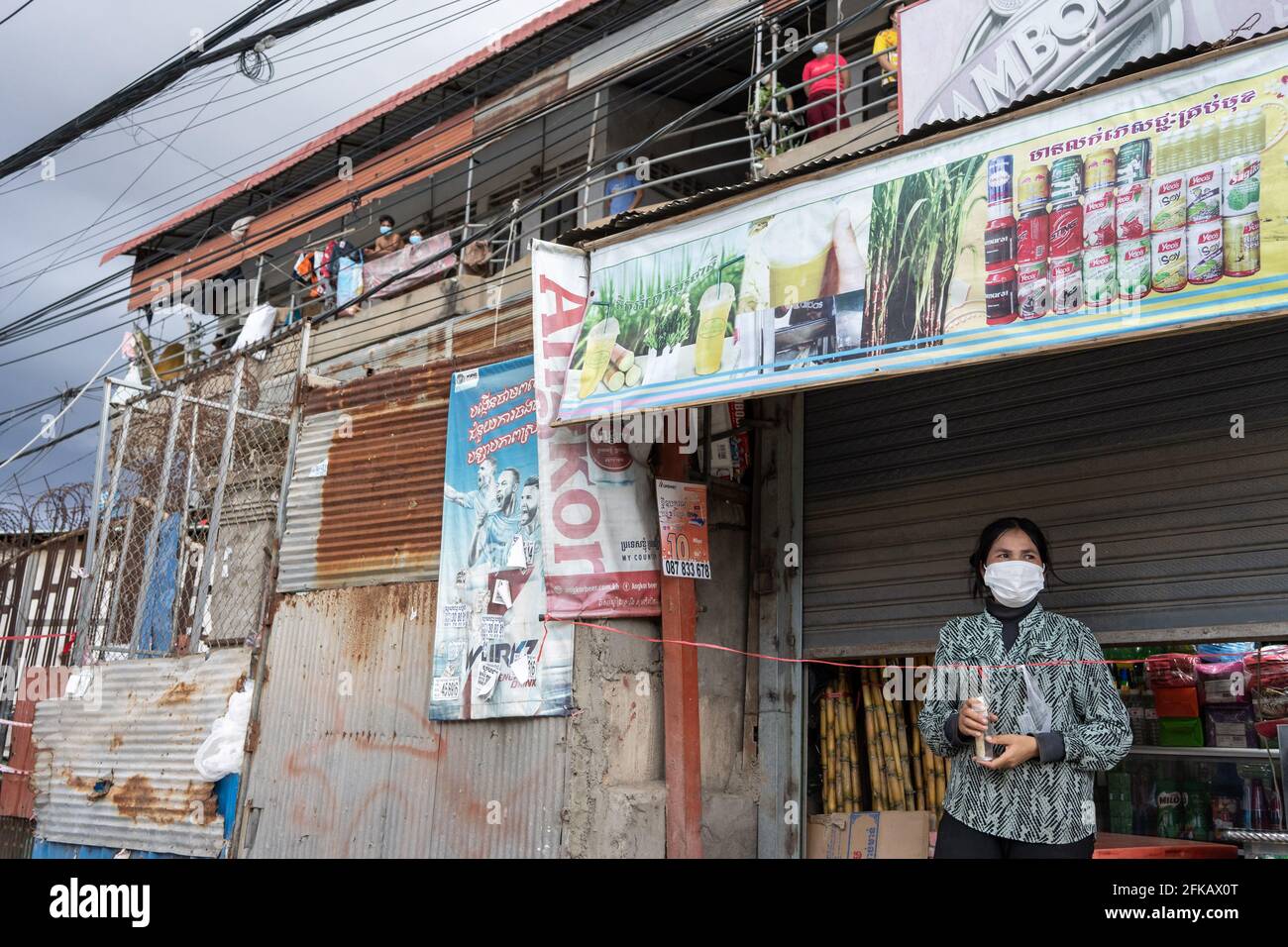 Phnom Penh, Kambodscha. April 2021. Bewohner einer Roten Zone bleiben während der Sperre in Innenräumen.Phnom Penh bleibt weiterhin gesperrt, da Kambodscha drastische Maßnahmen ergreift, um die Ausbreitung seines bisher schlimmsten COVID-19-Ausbruchs zu reduzieren. Die Sperre hat viele von ihnen aus der Arbeit gezwungen, darunter Fabrikarbeiter und Marktverkäufer, was die ärmsten Bewohner der Städte in Schwierigkeiten gebracht hat oder nicht in der Lage ist, sich grundlegende Notwendigkeiten zu leisten. Credit: Andy Ball/SOPA Images/ZUMA Wire/Alamy Live News Stockfoto