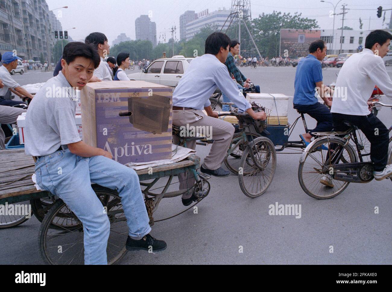 Ein junger Mann bittet einen Wanderarbeiter, einen IBM-Desktop-Computer, den er gerade mit einem Flachbettwagen in Zhongguancun, Peking, China, 1998 gekauft hat, zu transportieren. Stockfoto