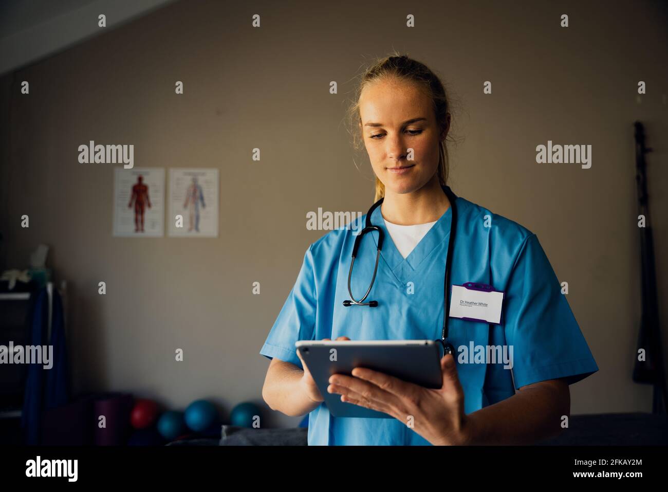 Kaukasische Krankenschwester, die sich auf die Online-Konsultation mit kranken Patienten vorbereitet Digitales Tablet in der Klinik Stockfoto