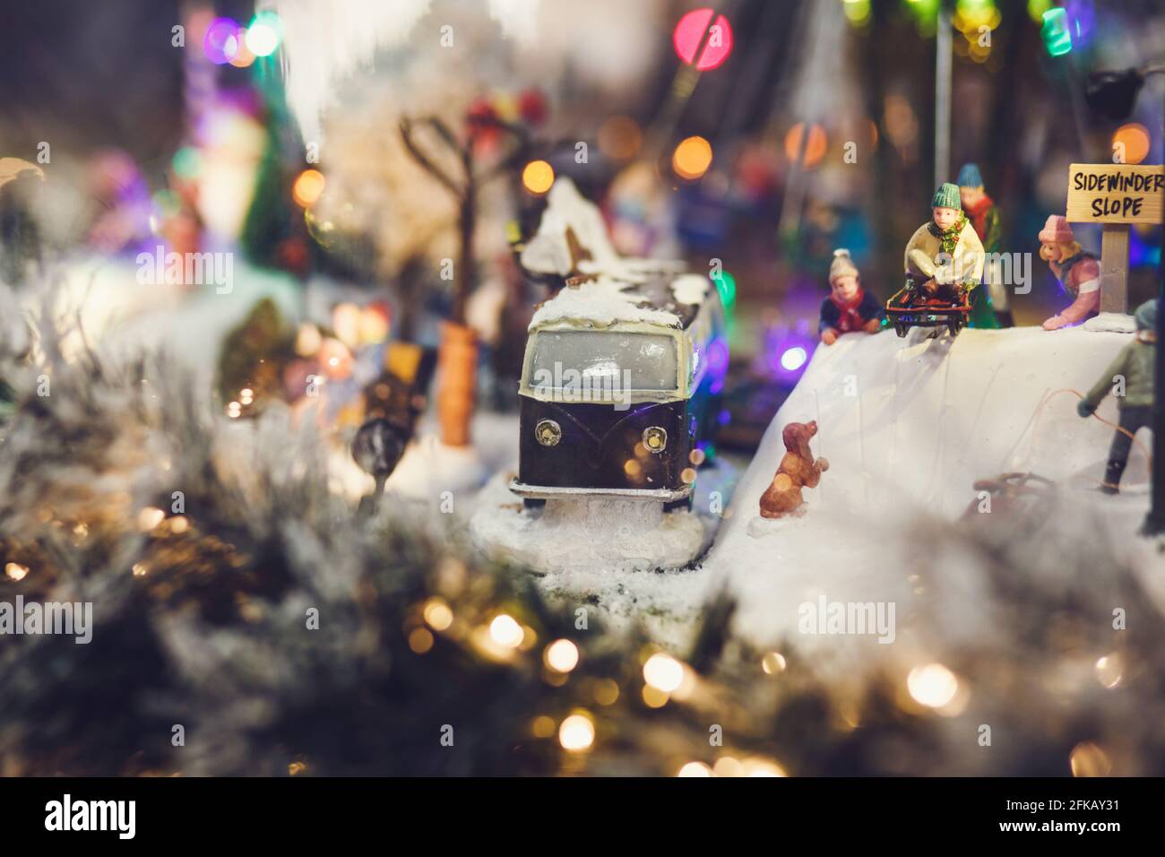 Miniaturbild der Weihnachtsszene-Retro-Bus und Menschen mit Schlitten Stockfoto