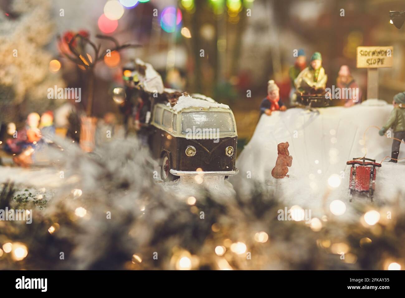 Weihnachtskonzept-Miniatur-Retro-Auto auf dem Hintergrund der Menschen Stockfoto