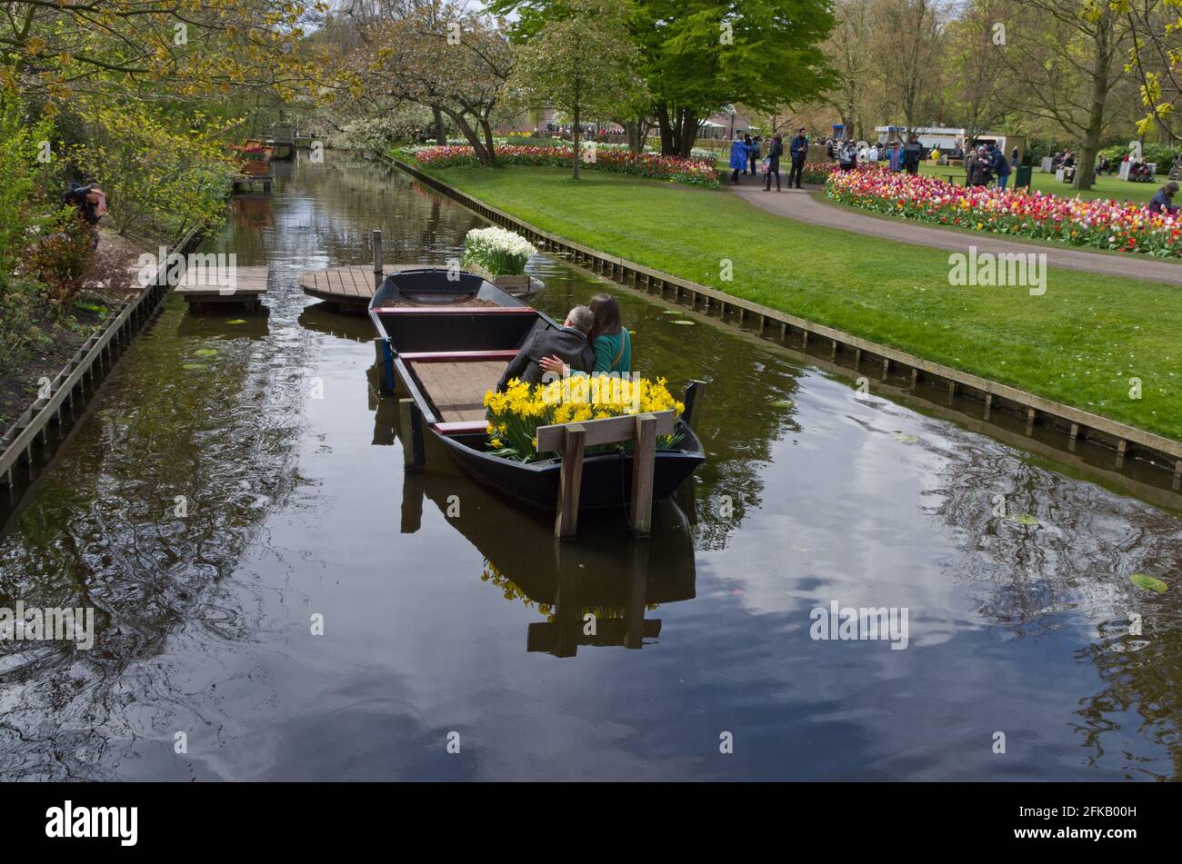 Keukenhof Gardens, Lisse, Niederlande; Paar posiert für Foto in einem mit Blumen bedecktem Boot Stockfoto