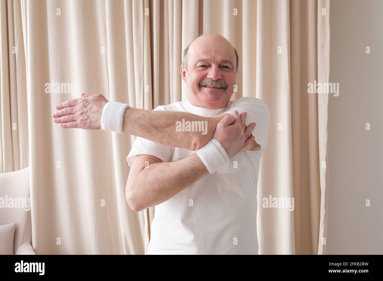Arzt, der zu Hause einen älteren männlichen Patienten impft. Stockfoto